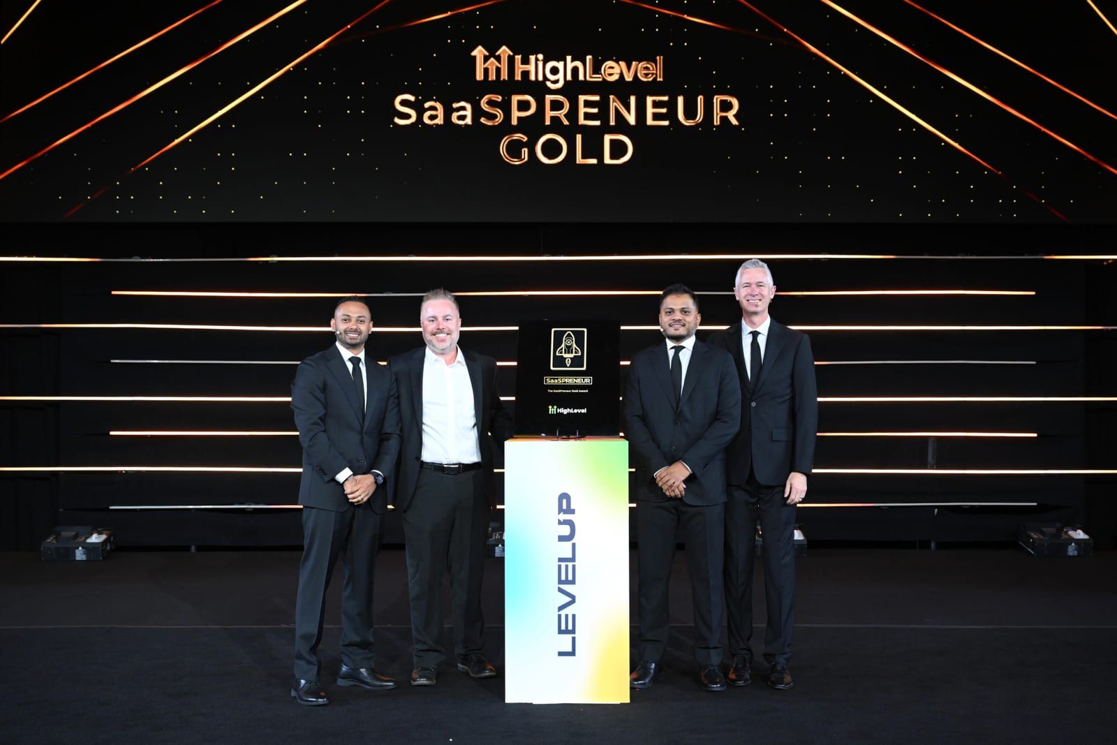 Jonathan Ferrell receiving the HighLevel SaaSPRENEUR Gold award on the LEVELUP stage with the HighLevel founders